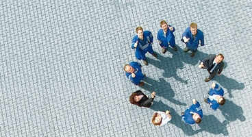 Birdview of people in different working-clothes standing in a circle