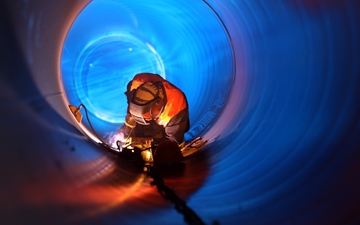 A welder welding in a pipe